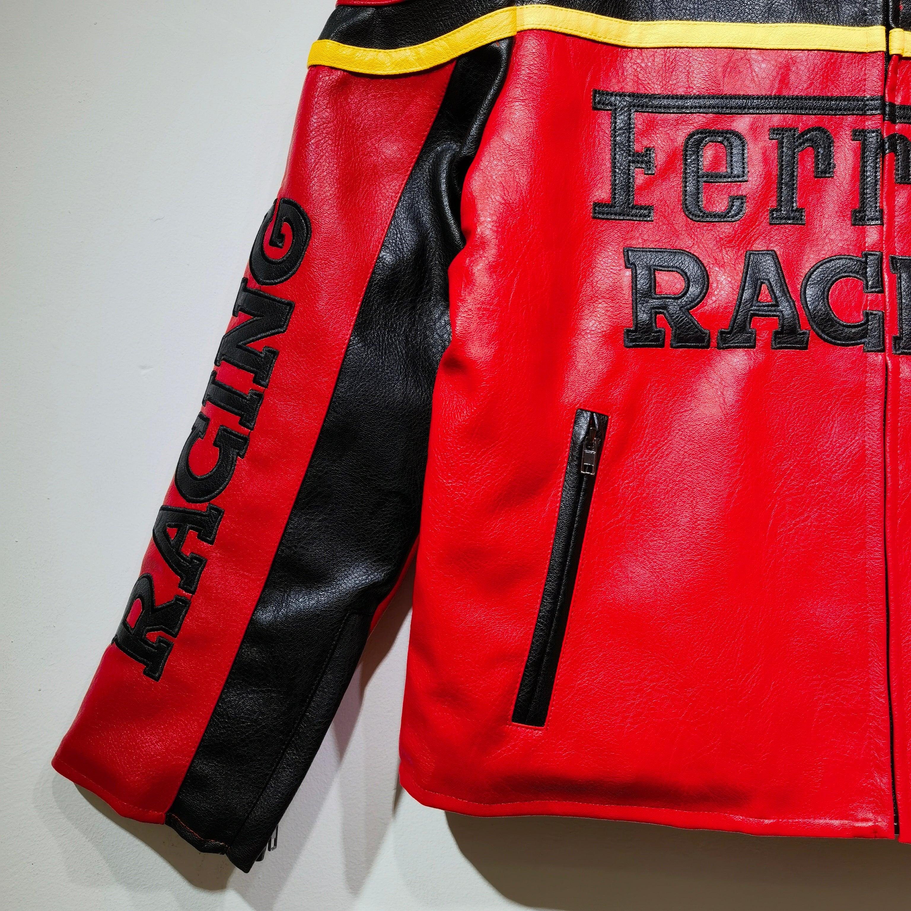 Red and black leather jacket with 'Ferrari Racing' text on a white background