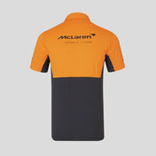 Orange and black polo shirt with McLaren logo on a gray background