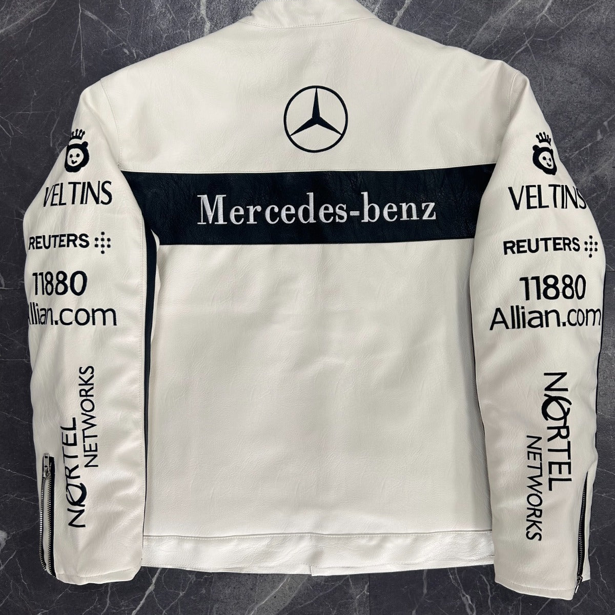 White racing jacket with Mercedes-Benz logo and various sponsor names on a dark marble background