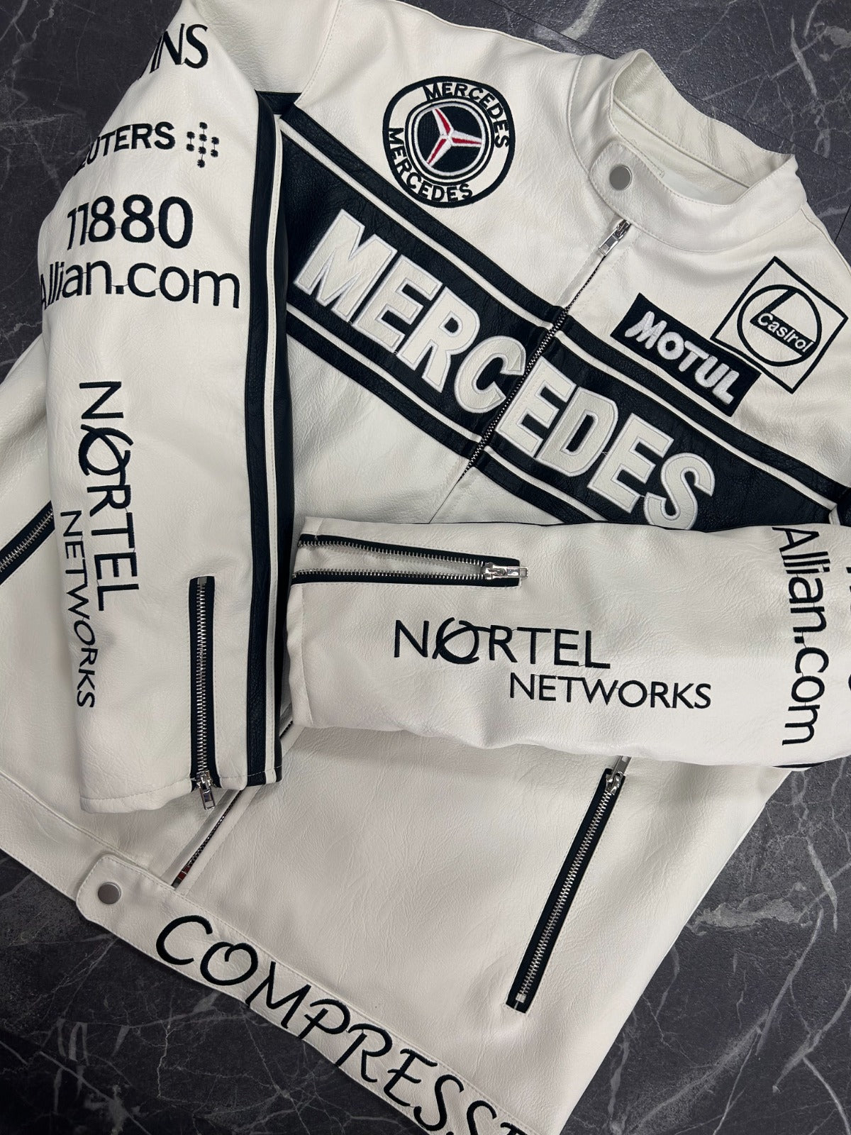 White jacket with Mercedes-Benz and Nortel Networks branding on a dark textured background