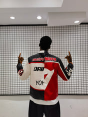 Person wearing a colorful jacket with brand logos in a modern indoor setting