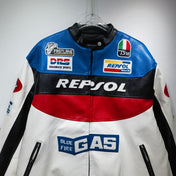Motorcycle racing jacket with various brand logos on a hanger against a gray background
