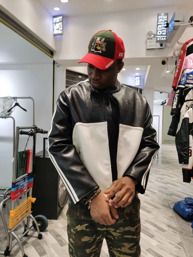 Person wearing a black and white jacket with a red and green cap in a store setting.